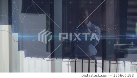 Analyzing data display businessman standing behind glass partition in corporate office, with graphs Analyzing data display businessman standing behind glass partition in corporate office, with graphs 135665198