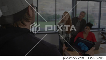Presenting man demonstrating car wireframe on tablet at meeting table, with laptop copy space Presenting man demonstrating car wireframe on tablet at meeting table, with laptop copy space 135665208