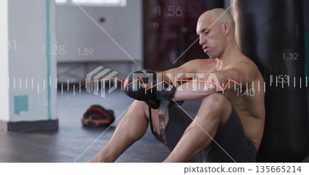 Adjusting male boxer tightening gloves in boxing gym, with heavy bag and data overlay, copy space 135665214
