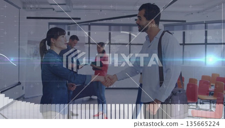 Shaking hands Asian businesswoman and Middle Eastern man in glass conference room, with binders 135665224