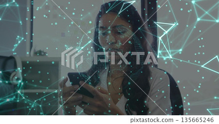 Tapping smartphone, office worker in white shirt displaying digital network overlay at office desk Tapping smartphone, office worker in white shirt displaying digital network overlay at office desk 135665246