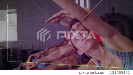 Stretching mid adult woman performing side stretch in fitness studio, with ring and brick wall Stretching mid adult woman performing side stretch in fitness studio, with ring and brick wall 135665402