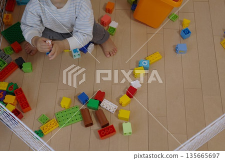 A bird's-eye view of a toddler engrossed in playing with blocks 135665697