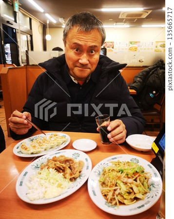 一位中年男子在中餐館喝酒 135665717