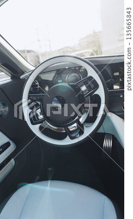 View of a car interior with a focus on the steering wheel and dashboard setup View of a car interior with a focus on the steering wheel and dashboard setup 135665843