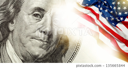 Benjamin Franklin on a hundred dollar bill with an American flag in the background Benjamin Franklin on a hundred dollar bill with an American flag in the background 135665844