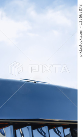 Shiny vehicle hood reflects sky and surroundings on a sunny day Shiny vehicle hood reflects sky and surroundings on a sunny day 135665878