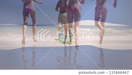 Sprinting four friends in swimsuits and board shorts on sandy shoreline, splashing ocean water 135666467