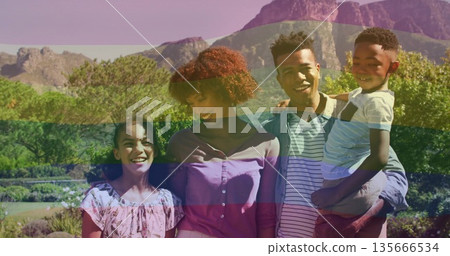 Standing family of four in spring outfits in landscaped garden, with flowering shrubs and mountains Standing family of four in spring outfits in landscaped garden, with flowering shrubs and mountains 135666534