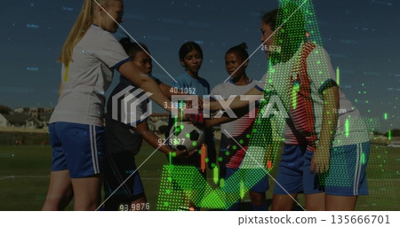 Huddling soccer players wearing jerseys stacking hands over ball on grass field, with chart overlay Huddling soccer players wearing jerseys stacking hands over ball on grass field, with chart overlay 135666701