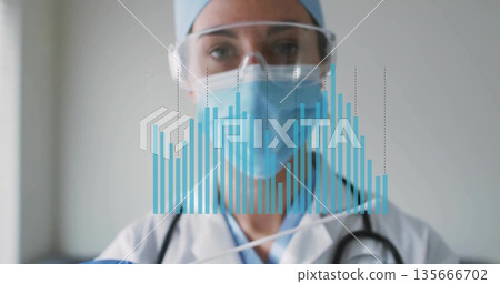 Displaying physician wearing labcoat and mask with stethoscope viewing digital bar chart in clinic 135666702