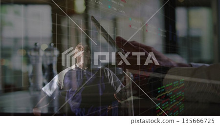 Leaning back male wearing navy polo shirt gazing upward in office, with tablet, financial charts Leaning back male wearing navy polo shirt gazing upward in office, with tablet, financial charts 135666725