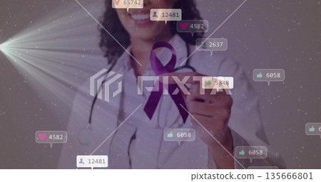 Smiling doctor wearing white coat and stethoscope pointing at purple ribbon in studio with bubbles Smiling doctor wearing white coat and stethoscope pointing at purple ribbon in studio with bubbles 135666801