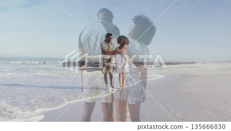 Walking barefoot couple holding hands at beach water's edge, showing double exposure overlay 135666830
