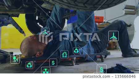 Inspecting mechanic in coveralls examining undercarriage on creeper in garage, with red tool chest Inspecting mechanic in coveralls examining undercarriage on creeper in garage, with red tool chest 135666846