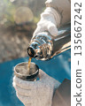 Coffee Pouring from Thermos into Cup on a Sunny Winter Day 135667242