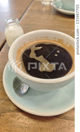 Cup of black coffee on a wooden table with milk bottle and spoon in a cozy cafe setting. The image represents morning routine, relaxation, caffeine break, and simple lifestyle comfort Cup of black coffee on a wooden table with milk bottle and spoon in a cozy cafe setting. The image represents morning routine, relaxation, caffeine break, and simple lifestyle comfort 135667705
