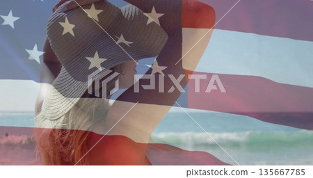 Standing adult woman wearing straw hat and red swimsuit at water's edge, with American flag overlay Standing adult woman wearing straw hat and red swimsuit at water's edge, with American flag overlay 135667785
