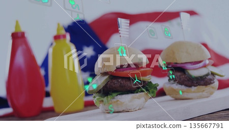 Two mini hamburgers resting on wooden board in studio, with flag backdrop ketchup mustard eco icons Two mini hamburgers resting on wooden board in studio, with flag backdrop ketchup mustard eco icons 135667791