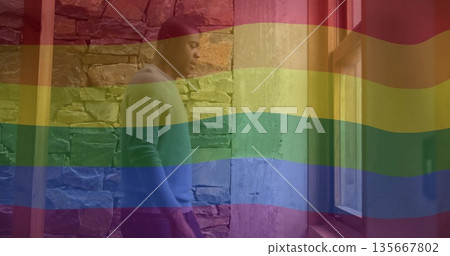 Gazing man wearing light sweater in stone hall with beams, window, rainbow overlay, copy space 135667802