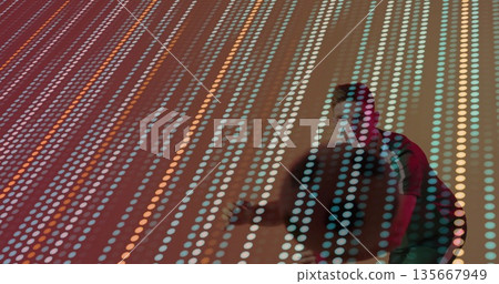 Leaning forward man wearing red jacket interacting with LED panel in gallery space, copy space 135667949
