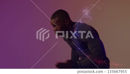 Leaning male athlete in compression shirt catching breath in studio, with gradient particle swirls Leaning male athlete in compression shirt catching breath in studio, with gradient particle swirls 135667955