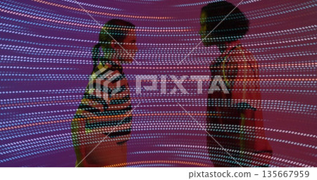 Two women standing face to face in art gallery space, with colored circular light projections Two women standing face to face in art gallery space, with colored circular light projections 135667959
