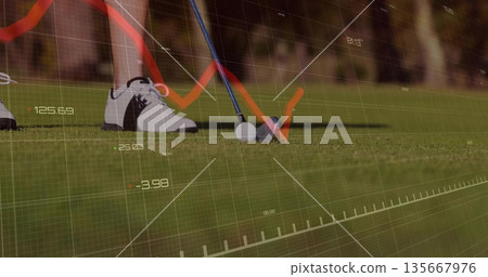 Poising club head behind golf ball on golf course turf, showing numeric data overlay and chart 135667976