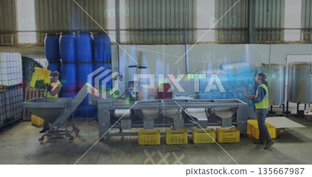 Tipping yellow produce crate into angled hopper on conveyor in plant, male worker monitoring tablet Tipping yellow produce crate into angled hopper on conveyor in plant, male worker monitoring tablet 135667987