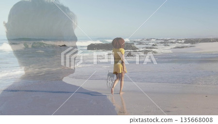 Barefoot woman wearing yellow sundress walking along sandy beach, with dog on leash and ocean waves Barefoot woman wearing yellow sundress walking along sandy beach, with dog on leash and ocean waves 135668008