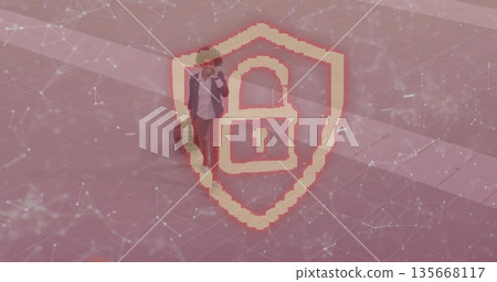 Walking woman in blazer pulling suitcase, talking on smartphone at plaza with cybersecurity overlay Walking woman in blazer pulling suitcase, talking on smartphone at plaza with cybersecurity overlay 135668117