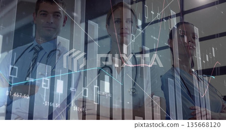 Medical professionals wearing uniforms crossing arms in hospital with stethoscopes, chart overlay Medical professionals wearing uniforms crossing arms in hospital with stethoscopes, chart overlay 135668120