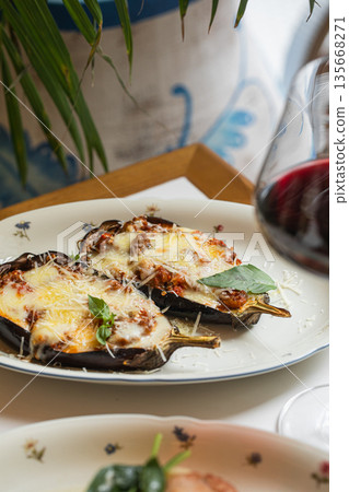 Baked eggplant halves with melted cheese Baked eggplant halves with melted cheese 135668271