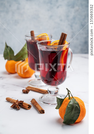 Two glasses of mulled wine, orange, cinnamon, and star anise on a marble background with spice Two glasses of mulled wine, orange, cinnamon, and star anise on a marble background with spice 135669382
