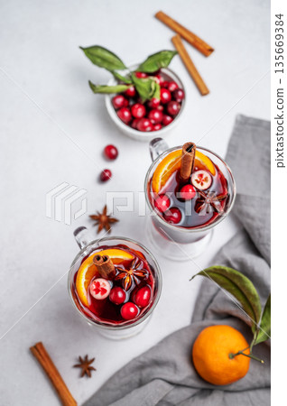 Two glasses of mulled wine, orange, cranberry, cinnamon, and star anise on a light background Two glasses of mulled wine, orange, cranberry, cinnamon, and star anise on a light background 135669384