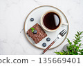 Chocolate brownie on a plate and a cup of espresso coffee on a marble background 135669401