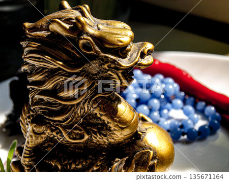 Chinese dragon statuette and blue beads Chinese dragon statuette and blue beads 135671164