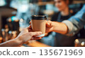 A barista serves coffee to go in a cozy cafe, freshly brewed coffee, the atmosphere of a small establishment, a warm morning mood 135671969