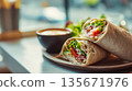 A fresh vegan wrap with crispy vegetables, a healthy plant-based lunch, served at a cafe table, a light snack option 135671976
