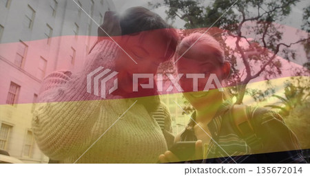 Leaning teen friends checking smartphone screen in campus courtyard, with two backpacks and pendant 135672014