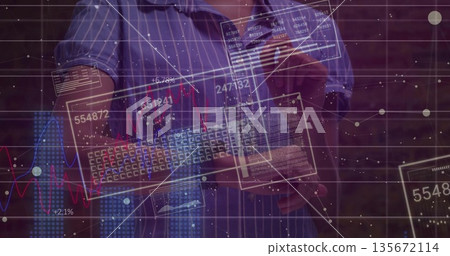 Man wearing blue shirt holding keyboard, swiping data panels at brick wall with holographic charts 135672114