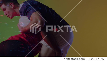 Two rugby players making tackle in studio, wearing jerseys with rugby ball and gradient background Two rugby players making tackle in studio, wearing jerseys with rugby ball and gradient background 135672197