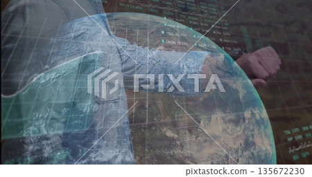 Glancing businessman in blue shirt, tie checking wristwatch in office, holographic globe, charts 135672230