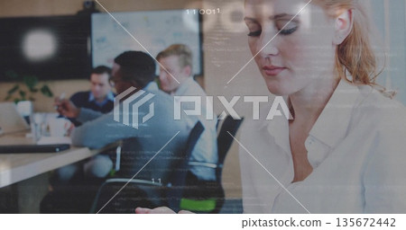 Using tablet woman in button?down shirt reviewing notes in meeting room, with laptops, copy space 135672442