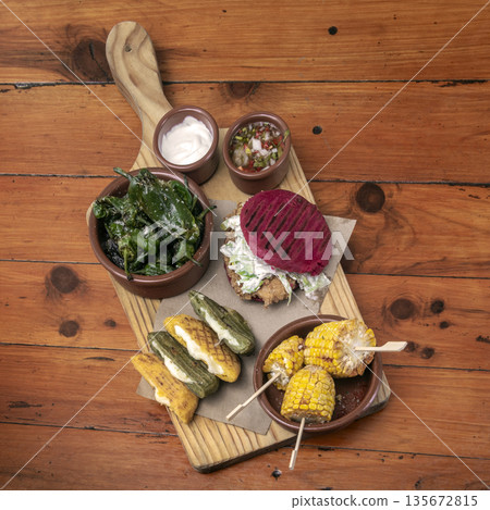 mixed colombian and venezuelan snack food platter on wooden restaurant table 135672815