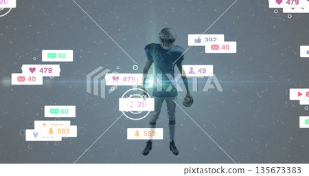 Standing football player wearing helmet pads gripping ball in digital arena with social media icons 135673383