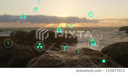 Floating circular badges displaying green energy icons over volcanic rocks by sea at sunset 135673415