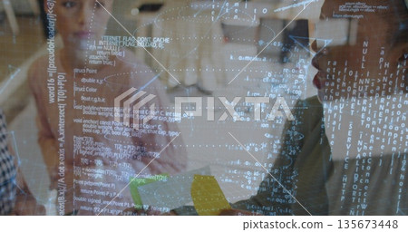 Mentor wearing blouse guiding mentee exploring 3D code projection in tech lab, with yellow block Mentor wearing blouse guiding mentee exploring 3D code projection in tech lab, with yellow block 135673448