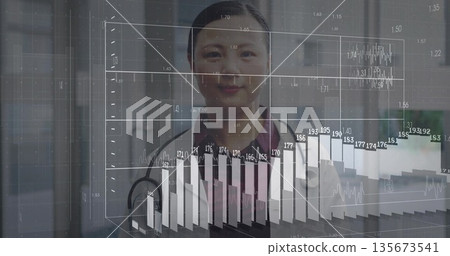 Nurse in burgundy scrubs analyzing charts and grid in clinic hallway, with stethoscope 135673541