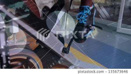Pedaling foot in black cycling shoe with blue laces on stationary bike at gym, digital overlays Pedaling foot in black cycling shoe with blue laces on stationary bike at gym, digital overlays 135673646